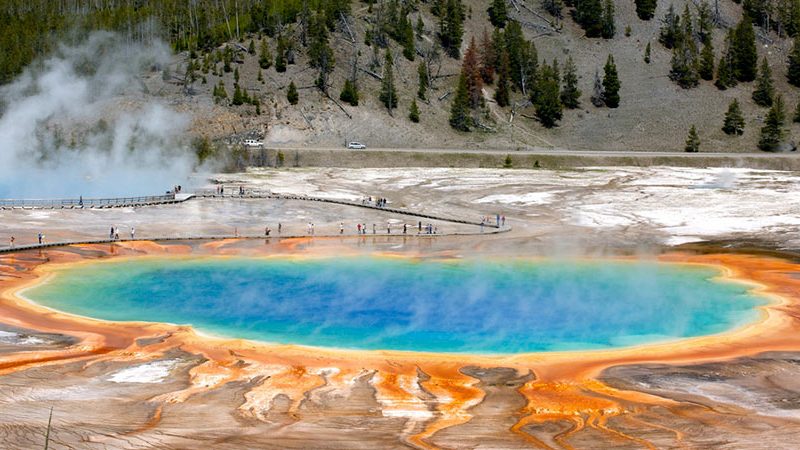 Yellowstone grand prismatic pool with people hiking